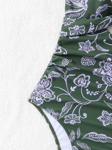 Gros plan du maillot de bain vert foncé à fleurs avec détails froncés et tissu doux