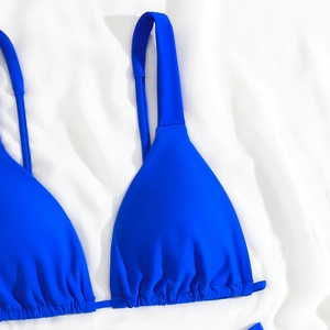 Detailed close-up of royal blue bikini top with ruched triangle cups and wide straps