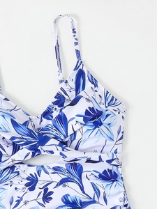 Détail du maillot de bain à fleurs bleues avec décolleté en V torsadé et fines bretelles