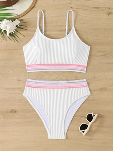 Bikini bianco a coste a vita alta con strisce rosa su sfondo di legno chiaro naturale