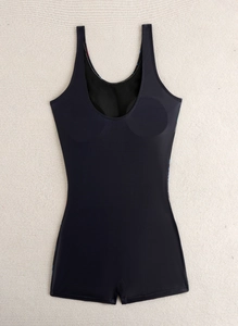 Detail of black one-piece boyshort swimsuit with U-neck and built-in chest pads on beige mat
