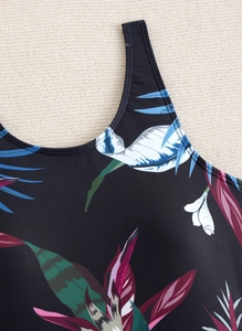 Close-up of tropical floral print on black swimwear fabric with durable double-stitched seams