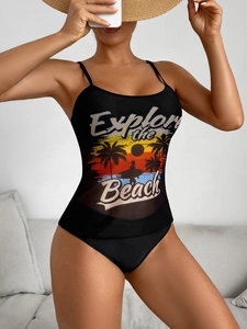 Detail of black swimsuit featuring sunset beach print and Explore the Beach artistic text