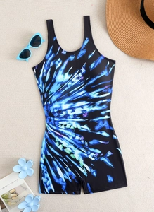 Close-up of black one-piece swimsuit with blue tie-dye print and vacation accessories