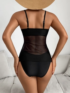 Detail of black swimsuit featuring sheer mesh waist panels and an elegant backless design