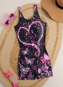 Flat lay of women's one-piece swimsuit with heart patterns on a straw beach mat
