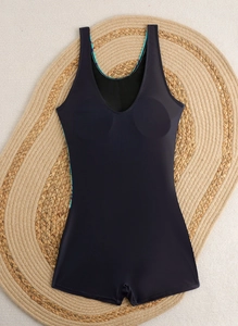 Detailed top view of a black one-piece swimsuit with blue patterned trim on a beach mat
