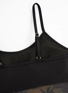 Detail of black mesh bikini top showing adjustable thin straps and precise stitching