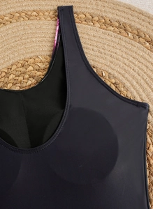 Detailed macro view of the built-in chest pads and floral strap on a black swimsuit