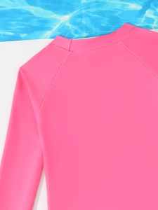 Detail van een felroze rash guard zwemtop met lange mouwen voor meisjes en raglanmouwen