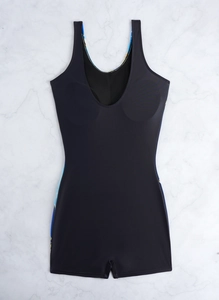 Flat lay of black one-piece romper swimsuit with U-neck on white marble background
