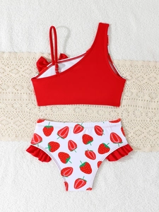 Detail of red one-shoulder bikini top with bow and strawberry print ruffled bottoms