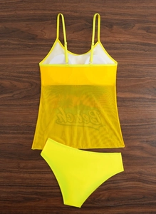 Detail of neon yellow tankini with mesh overlay and Beach print on wood background