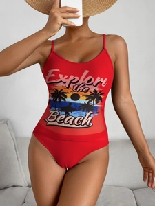 Detail of red one-piece swimsuit featuring Explore the Beach graphic print and thin straps