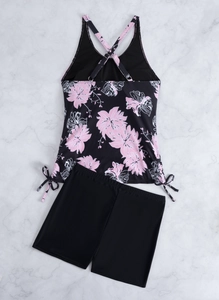 Detail van bloemen tankini-top met gekruiste bandjes en trekkoord aan de zijkant op marmer