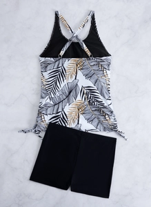 Detail van bloemen tankini-top met trekkoord aan de zijkant en zwarte hoge zwemshorts