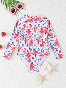 Dettaglio del costume da bagno bambina a maniche lunghe con stampa tropicale e zip