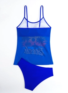 Flat lay of blue two-piece swimsuit with beach print and mesh panel on white background