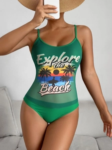 Close-up of green bikini with mesh panels and Explore the Beach print on a model