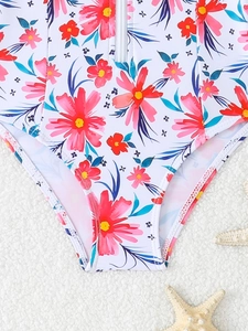 Dettaglio del costume da bagno floreale per bambina con cerniera frontale e motivi tropicali