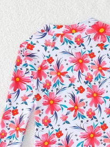 Dettaglio maglia da nuoto per bambini con stampe floreali tropicali e maniche raglan