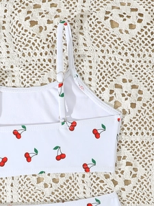 Detail van witte bikini-top voor meisjes met kersenprint en verstelbare schouderbandjes
