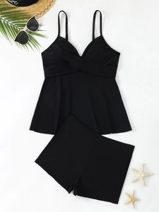 Flatlay des schwarzen zweiteiligen Tankini-Sets mit verstellbaren Trägern und Strand-Deko