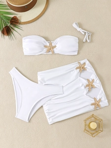 Detailed view of white three-piece bikini set with metallic starfish charm and skirt