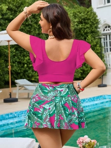 Vista posteriore di un costume a due pezzi con top rosa a balze e gonna a stampa tropicale