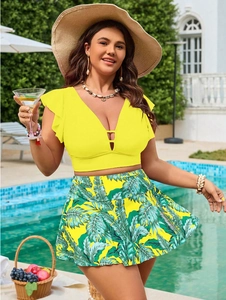 Dettaglio del top bikini giallo con scollo a V, maniche a volant e gonna con stampa tropicale