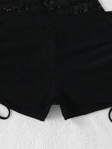 Detail von schwarzen High-Waist Tankini-Badeshorts mit Spitzenbesatz und Seitenschlaufe