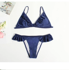 Detailed flat lay of dark blue bikini set with ruffle trim and shiny stretch fabric