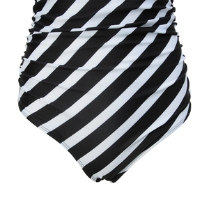 Detail of one-piece swimsuit featuring black and white diagonal stripes and slimming side ruching