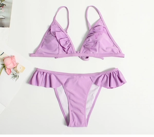 Detailed top view of light purple bikini set with ruffled edges on white background