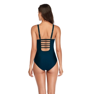Detail of adjustable straps and back cutout straps on a dark green one-piece swimsuit