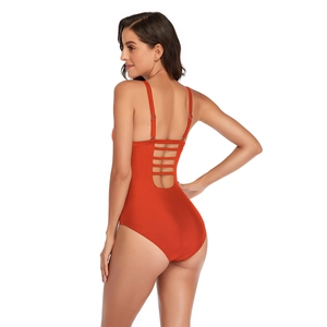 Detail of sexy orange one-piece swimsuit featuring multi-strap backless design and ruching