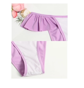 Detail of purple ruffled swimwear fabric showing zigzag stitching and soft mesh lining