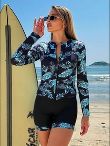 Close-up of tropical palm leaf print long sleeve surf top with a front zipper and shorts