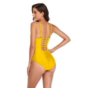 Detail view of bright yellow one-piece swimsuit featuring strappy back and adjustable straps