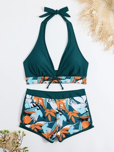 Dettaglio dei pantaloncini da bagno a vita alta con stampa tropicale in verde smeraldo