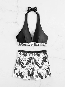 Close-up of halter bikini top and floral boyleg bottoms on a textured grey background