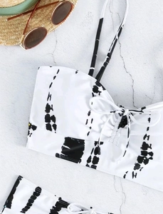 Flat lay of tie-dye high waist bikini set with bow detail and vacation accessories