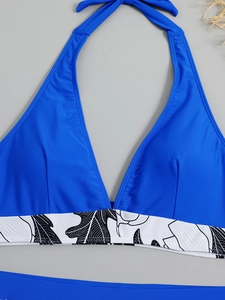 Detail of dark blue halter bikini top with black and white tropical leaf pattern band