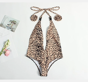 Flat lay of a leopard print deep V-neck one-piece swimsuit with neck tie and side buckles