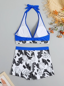 Flat lay of royal blue halter bikini top with high-waisted floral print swim shorts