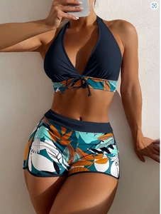 Dettaglio del top bikini halter blu navy con pantaloncini a stampa tropicale