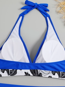 Detail of blue halter bikini top with front knot and tropical floral pattern waistband