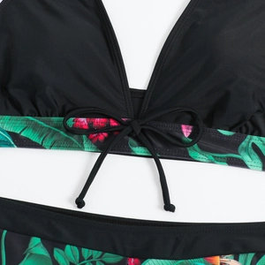 Dettaglio di bikini a vita alta con scollo a V, fiocco e stampa di foglie tropicali