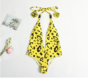 Detailed flat lay of a yellow leopard print one-piece swimsuit with floral strap accents