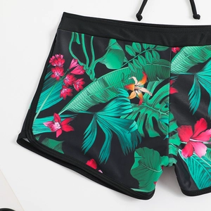 Dettaglio del pezzo sotto bikini a vita alta con stampa floreale tropicale e spacchi